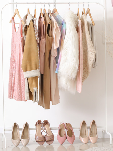 woman's closet with hanging clothing and shoes